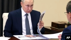 Підлеглі Путіна схильні до підвищеного оптимізву у звітності і заниження ризиків для уникнення критики і покарань, - звіт RUSI. Фото: президент РФ з губернатором Самарської області Дмитром Азаровим, 28 березня, 2023 р. Mikhail Klimentyev, Sputnik, Kremlin Pool Photo via AP