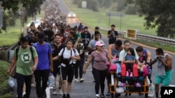 资料照片:移民沿着墨西哥恰帕斯州的高速公路行走,希望到达北部边境并最终进入美国。(2024年10月22日)