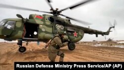 俄罗斯国防部今年2月19日发布的照片显示,一名俄罗斯海军陆战队士兵正在白俄罗斯一个训练基地演练快速部署。这是勇气-2022军演的一部分。-照片由美联社提供。