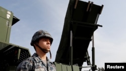 一名日本陆上自卫队成员站在PAC-3导弹拦截器前。(2018年1月18日)