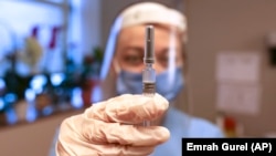 土耳其伊斯坦布尔的医护人员手持新冠疫苗。（2020年12月21日）