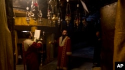 信奉基督教的亚美尼亚人在伯利恒圣诞教堂的圣诞洞内祈祷。(2019年12月24日)
