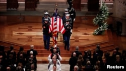 Members of the clergy and a military honor guard carrying the flag-draped casket depart at the conclusion of the state funeral for former President George H.W. Bush in the Washington National Cathedral in Washington, Dec. 5, 2018.