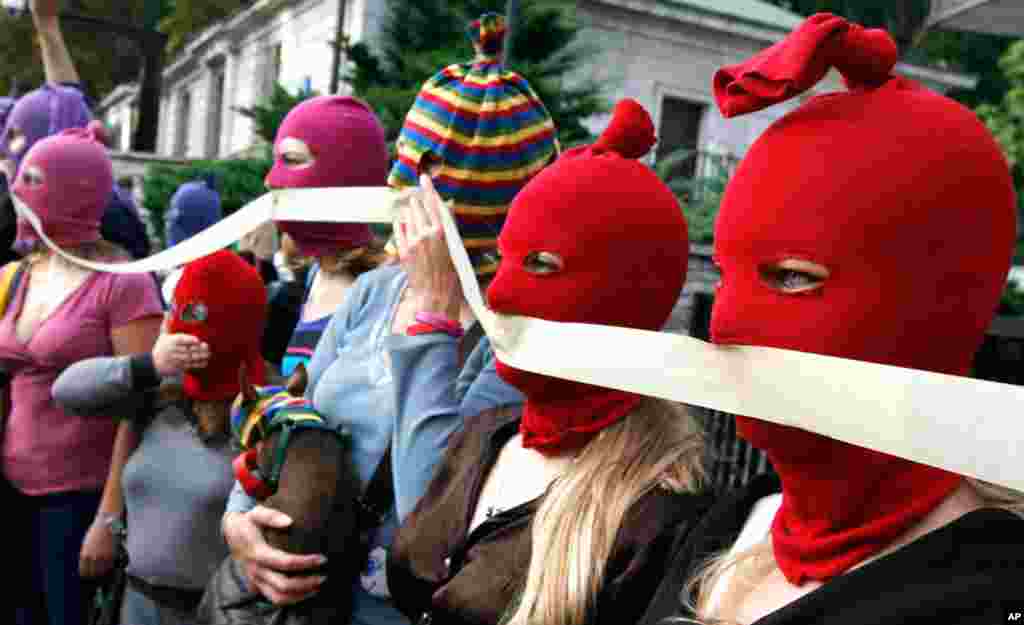 P在俄罗斯驻华沙大使馆外面一批戴着面罩的活动人士举行示威,要求释放“Pussy Riot”三名歌手