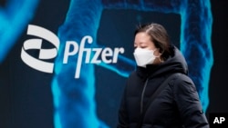 一名妇女走过在美国纽约的辉瑞公司总部(2021年2月5日)。