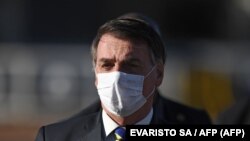资料照：巴西总统贾尔·博尔索纳罗(Jair Bolsonaro)在巴西利亚阿尔沃拉达宫举行部长级会议前举行升旗仪式时戴着口罩。(2020年5月12日)