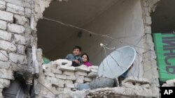 Сирійські діти у частково знищеному будинку