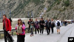 大多数是俄罗斯人2022年9月28日越过格鲁吉亚和俄罗斯之间的边界后行走。他们许多人是为了逃避俄罗斯的征兵令。(美联社照片)