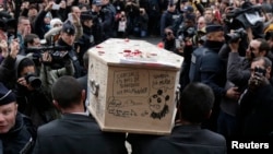 在巴黎附近,人们抬着《查理周刊》恐怖袭击事件遇难者的棺材(2015年1月15日)