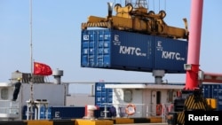 中国江苏省南通的一个港口的吊车吊起一个集装箱。(2020年3月16日)