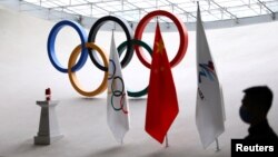 一名保安在北京奥运大厦中守卫奥运火种和旗帜。(2021年12月10日)