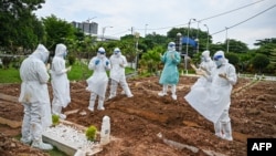 မလေးရှားနိုင်ငံ ကွာလာလမ်ပူမြို့သချိုင်းတခုတွင်း ကိုဗစ်ရောဂါနဲ့သေဆုံးသူတဦးအား မြှုပ်နှံစဉ် (ဓာတ်ပုံ - AFP)