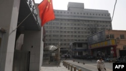 一名戴着口罩的女子走过北京复兴医院。(2020年2月21日)