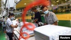 中国湖北武汉格力厂的工人在制作空调机的生产线上。(2021年8月9日)