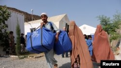 资料照片:阿富汗难民在人道救援站领取食品(2016年10月22日)