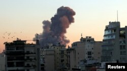 贝鲁特冒起的浓烟,真主党的灯塔电视台说,这是以色列越境空袭造成的。(2024年9月27日)