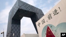 资料照: 中国央视在北京总部大楼下的一块宣传牌。