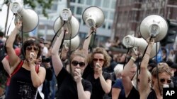 Women hold up megaphones during a protest against the G-20 summit in Hamburg, Germany, July 8, 2017.