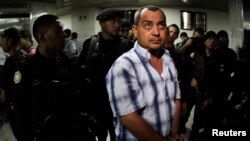 FILE - Suspect Elio Lorenzana Cordon is escorted by police officers in the Supreme Court in Guatemala City, Guatemala, Nov. 8, 2011.
