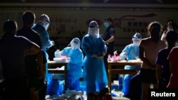 资料照:云南医护人员在与缅甸接壤的边境城市瑞丽的一个居民区进行新冠病毒核酸检测。(2020年9月16日)