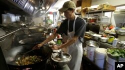 康涅狄克州一家餐厅的厨房里,一名厨师正进行烹饪。