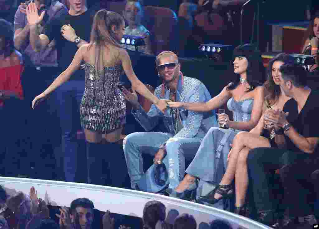 在MTV颁奖典礼上,美国流行歌星爱莉安娜·格兰德拉着歌星凯蒂·佩里(Katy Perry)的手(2014年8月24日)。歌星凯蒂·佩里和贾斯汀·比伯等人也作为嘉宾在6月4日曼彻斯特公益演唱会上献唱。