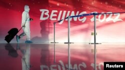 2022年1月31日,在北京冬奥会前,一名穿着防护服的人在北京首都国际机场内(路透社)。