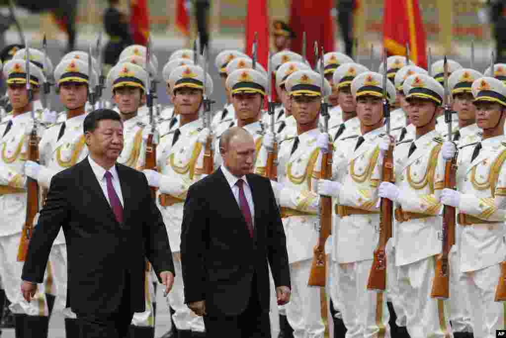 2018年6月8日北京人民大会堂外,俄罗斯总统弗拉基米尔·普京和中国国家主席习近平在欢迎仪式上检阅仪仗队。普京在出席上海合作组织领导人峰会前访问北京。该组织包括中国等7个亚洲国家和俄罗斯。中国学者荣剑在推特上写道:“中俄关系热烈,近乎结盟,但实际上两国人民都清楚,各有所图而已。历史的教训是,中俄交往最终吃亏的还是中国。 ”