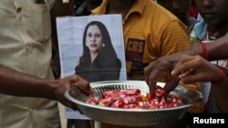 印度南部村庄图兰森德拉普兰村的村民手举哈里斯的照片,分发糖果庆祝该村村民的后代成为美国副总统。(2021年1月20日)