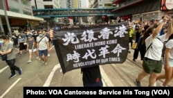 7月1日港版国安法实施第一日,数以万计香港人聚集在铜锣湾上街游行,有人高举被当局批评有港独含意的反送中运动旗帜(美国之音/汤惠芸)