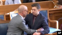 2021年11月19日,凯尔·里滕豪斯(Kyle Rittenhouse)在威斯康辛州基诺沙的法庭上听到无罪判决后与辩护律师交谈。