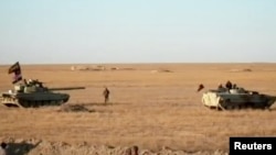 伊拉克军队的坦克和武装军车在叙利亚边界附近的沙漠地带中驻停。(2017年11月23日)