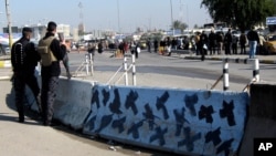 伊拉克安全部队守卫在巴格达汽车炸弹袭击现场。(2014年1月12日)