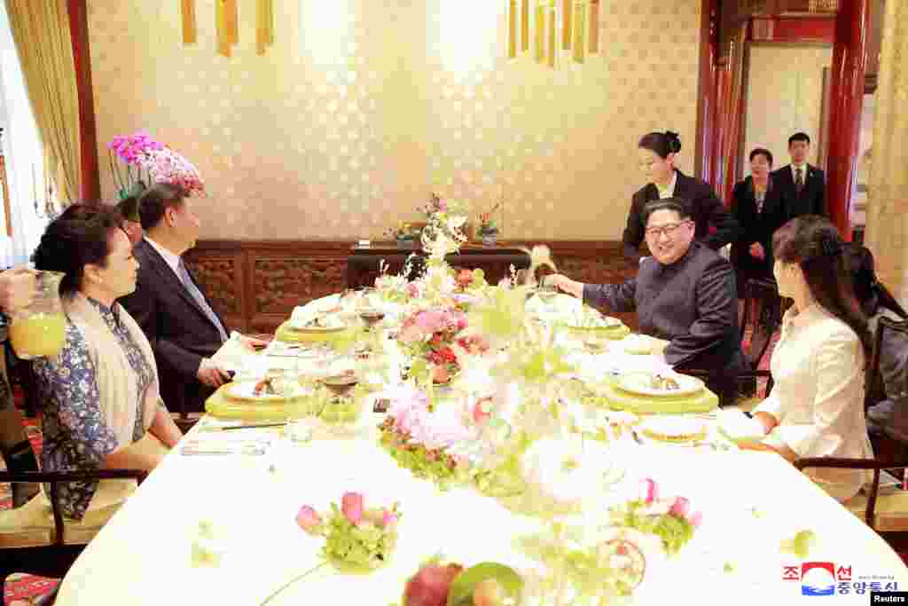 North Korean leader Kim Jong Un and wife Ri Sol Ju, and Chinese President Xi Jinping and wife Peng Liyuan meet in Beijing, China, in this undated photo released by North Korea's Korean Central News Agency (KCNA) in Pyongyang, March 28, 2018.