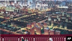 2011年7月人们骑自行车经过北京一座广告牌,广告牌显示了北京中央商务区的景象