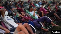 在柬埔寨金边,一家私人组织为三轮车驾驶员组织露天电影放映活动并向他们分发现金和食品。新冠病毒疫情严重冲击了当地旅游业。(2021年1月23日)