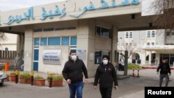 戴着口罩的黎巴嫩人走出收治黎巴嫩第一例新冠病毒病人的拉菲克·哈里里大学医院。 (2020年2月21日)