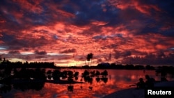 太平洋中部岛国基里巴斯,村民们在一个小湖旁看日落(2013年5月25日)。