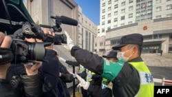 一名警察挡住记者的镜头阻止拍摄审讯公民记者张展的上海浦东新区法院外景。(2021年12月28日)