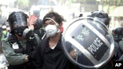 Police officers detain a protester near the Hong Kong Polytechnic University in Hong Kong, Monday, Nov. 18, 2019.