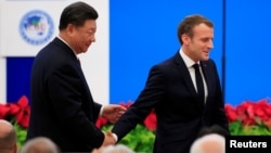 法国总统马克龙在上海举行的中国国际进口博览会开幕式上讲话后与中国国家主席习近平握手。(2019年11月5日)