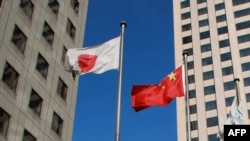 资料照:大连市内楼群中飘扬的中日国旗。(2012年12月31日)