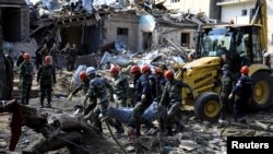 搜救人员将炮击遇难者遗体抬出废墟。阿塞拜疆10月11日称,亚美尼亚军队对占贾发动夜间炮击。(照片来自路透社 REUTERS/Umit Bektas)