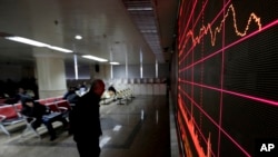 一名男子在北京一个股票交易所里观看电子屏幕显示的股市行情。(2016年1月26日)