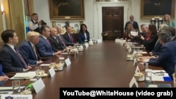 美国农业部长罗林斯在2025年7月8日的内阁会议上手持一张显示中国公民购买的美国农田地图,阐述中国购买美国农田的威胁。