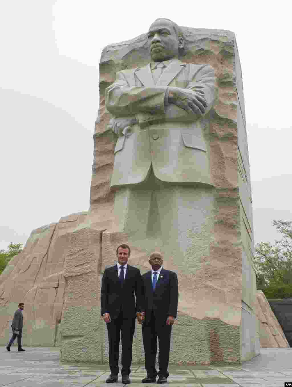 2018年4月25日,法国总统埃马纽埃尔·马克龙与美国民权倡导者、众议员约翰·刘易斯在华盛顿特区的马丁路德金雕像前合影。