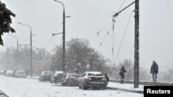 2024年1月8日,调查人员在乌克兰扎波罗热俄罗斯导弹袭击现场的受损汽车旁工作。(路透社照片)