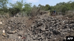 在敖德萨的一处公墓,当地居民站在被俄罗斯导弹炸出的弹坑边。(2023年7月19日)