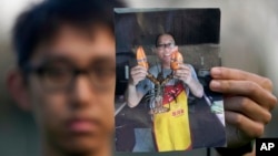 在美国加州帕洛阿尔托,李凯 (Kai Li) 的儿子哈里森·李 (Harrison Li) 拿着他的父亲李凯的照片。(2024年1月23日)