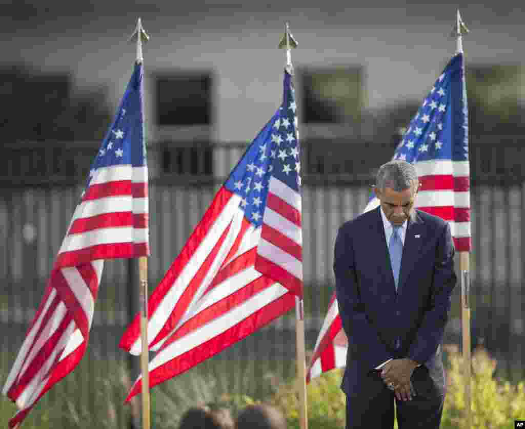 President Barack Obama bows his head during a moment of silence at the Pentagon during a ceremony to mark the 13th anniversary of the 9/11 attacks, Sept. 11, 2014.